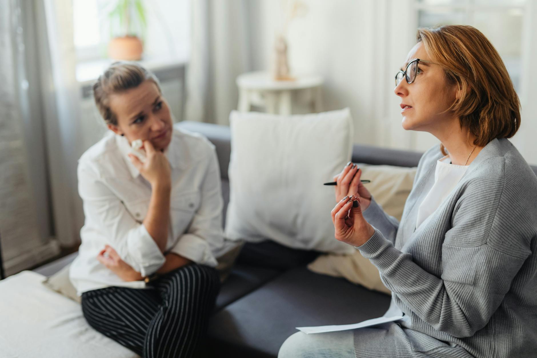 Two women engaged in a thoughtful discussion during a life coaching session.